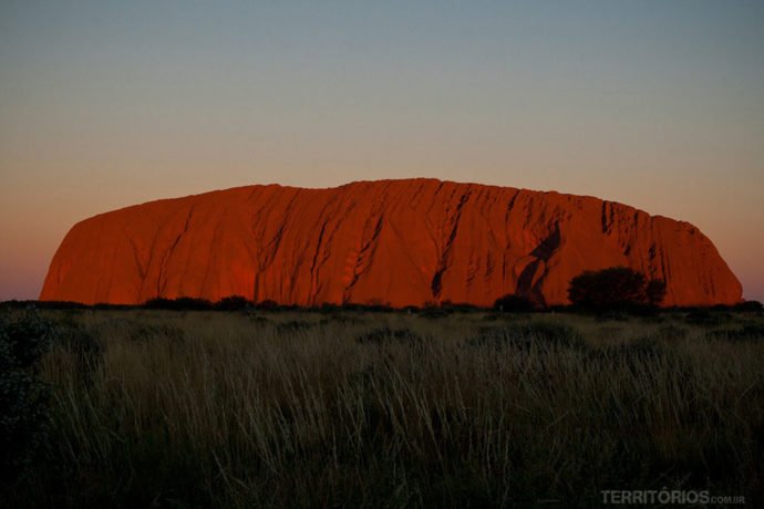 A inclinação do sol deixa a rocha vermelha como se estivesse pegando fogo Cores de Uluru