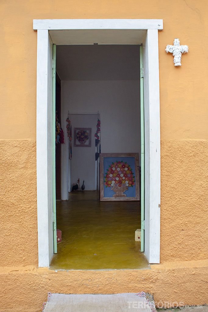 Cruz para receber Nossa Senhora na fachada da loja de artesanato
