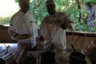 Cozinheiro e ajudante preparando o café da manhã na hora