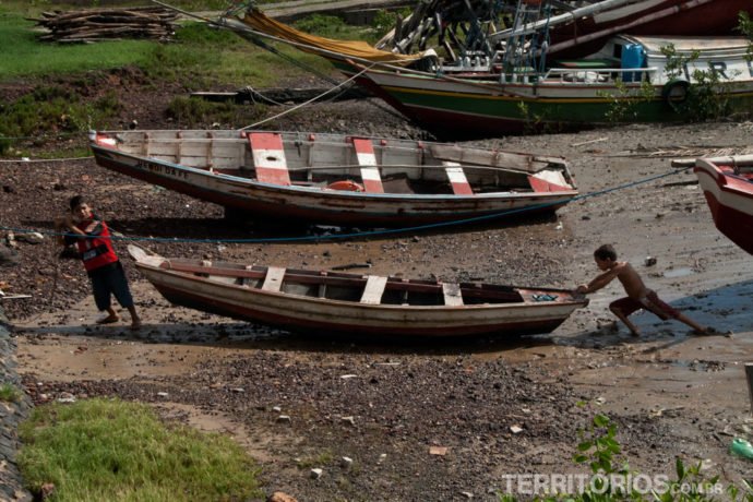Crianças tentando desencalhar o barco