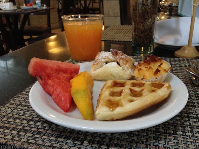 Feliz com frutas e doces no café da manhã