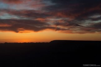 O sol começa a se apresentar atrás do paredão do North Rim O sol começa a se apresentar atrás do paredão do North Rim