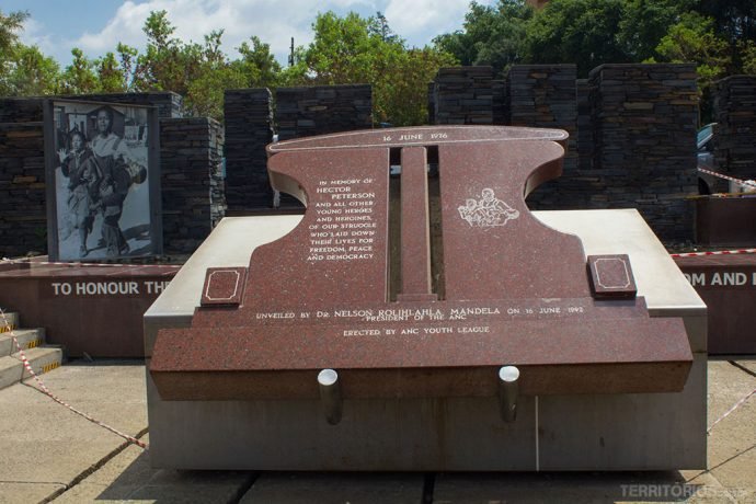 Foto da criança morta ao fundo e monumento em frente ao Museu Hector Pieterson